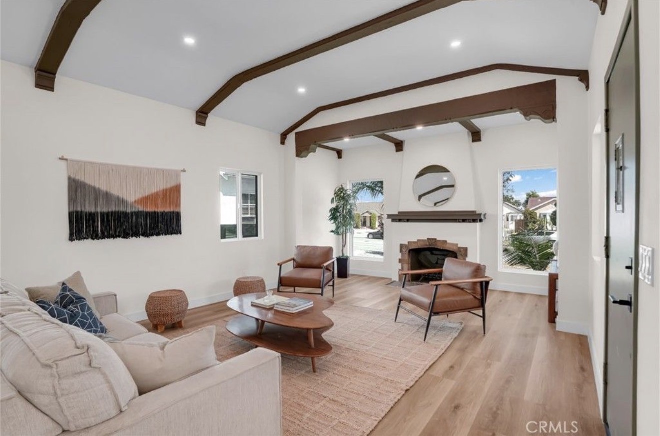 Living room with beamed ceilings and fireplace in the Spanish-style residence