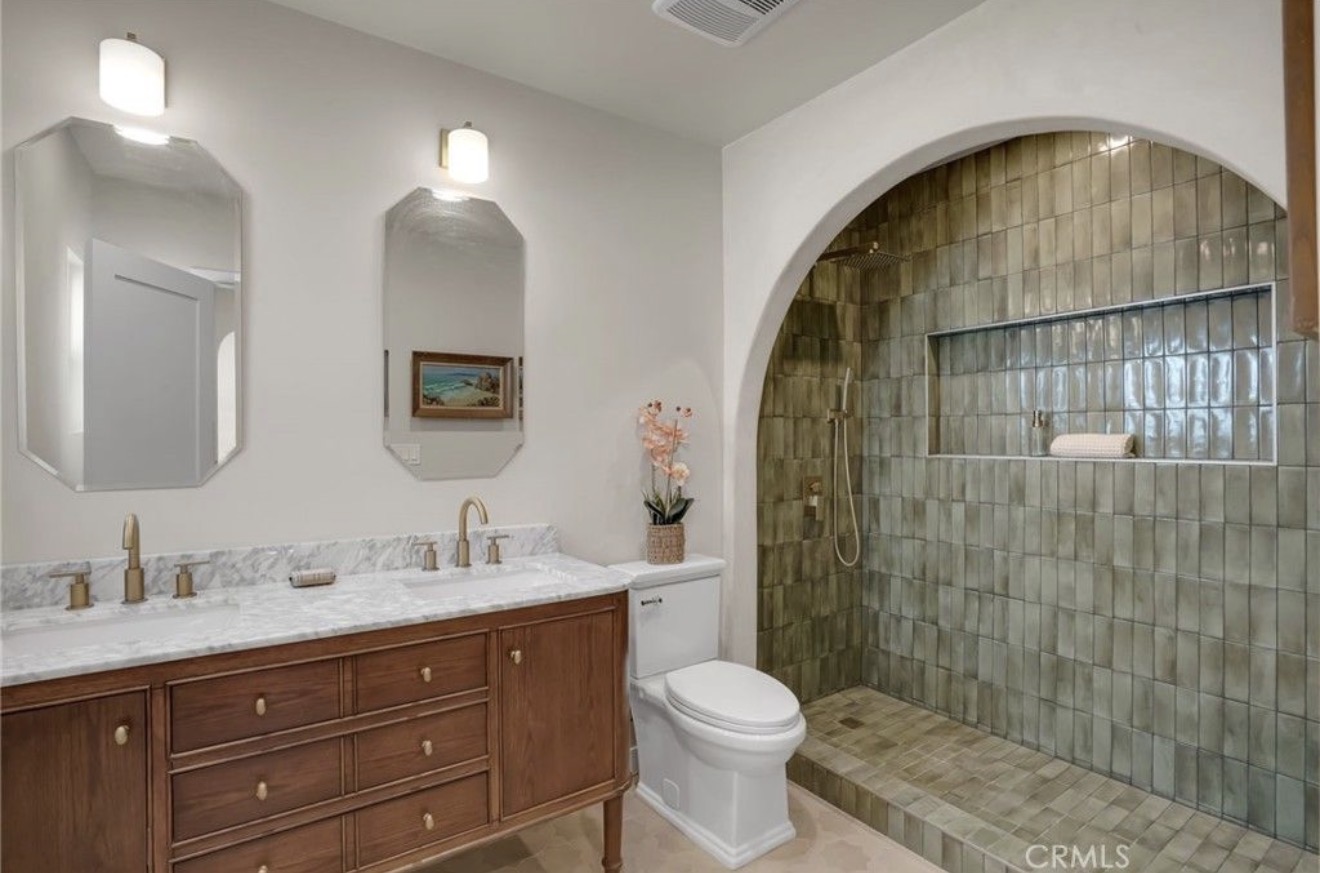 Updated primary bathroom with arched tiled shower