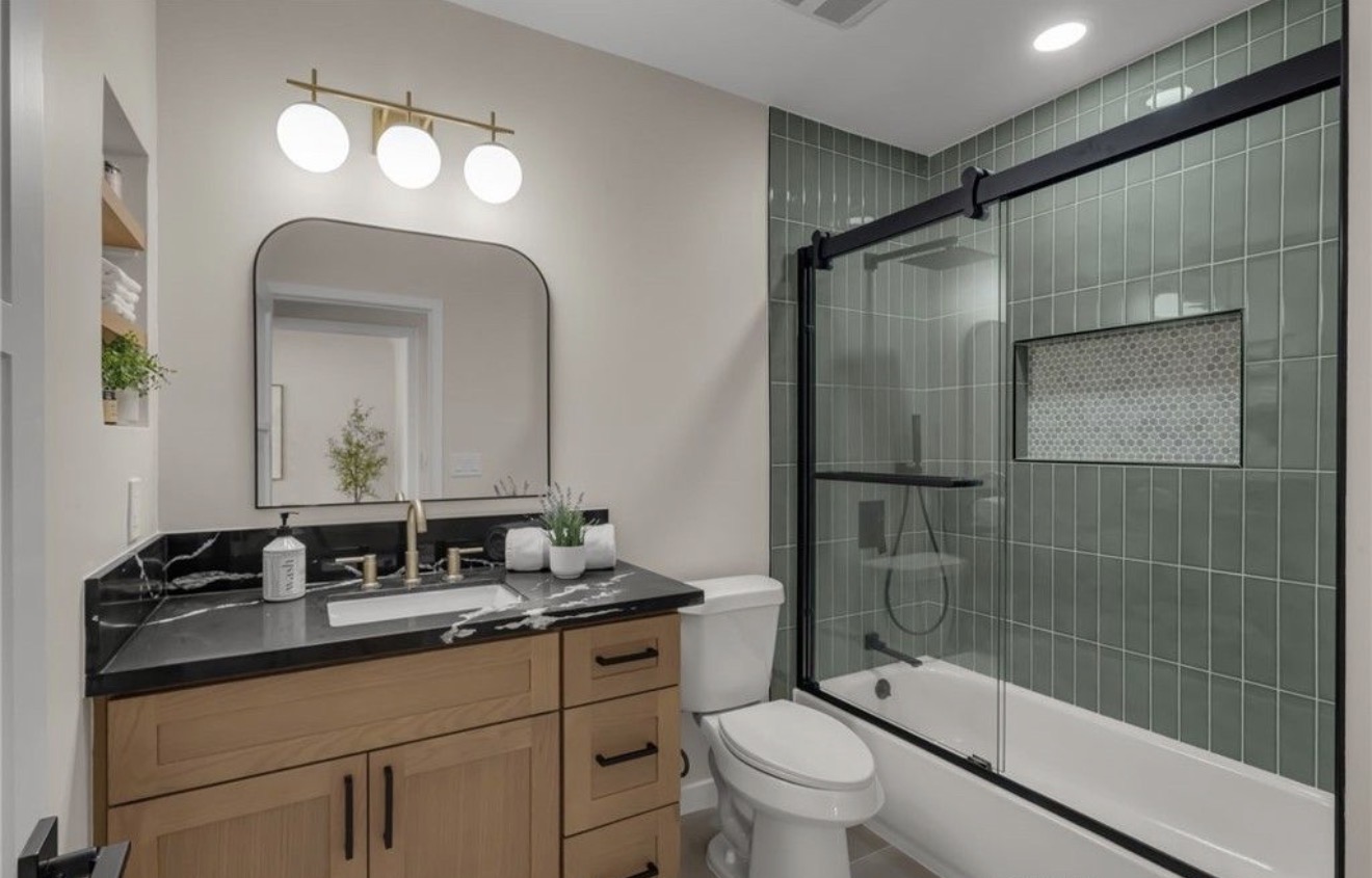 Renovated full bathroom with green tile in the View Park–Windsor Hills home
