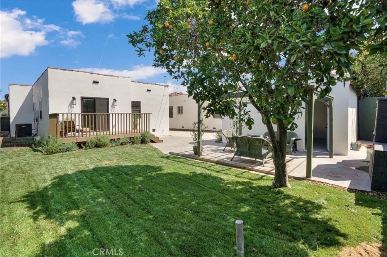 Rear lawn and outdoor living areas of the Spanish-style residence