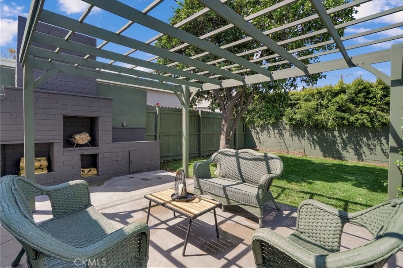 Pergola-covered outdoor terrace with fireplace